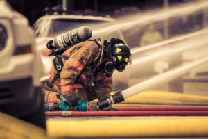 A firefighter putting out a fire using a water hose