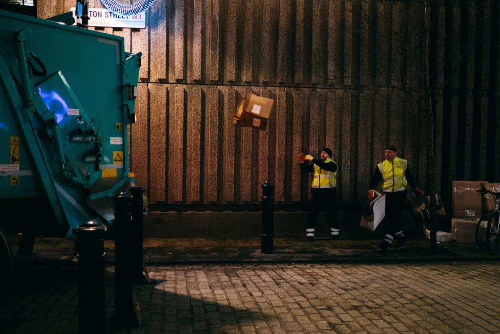 sanitation workers throwing trash in a truck