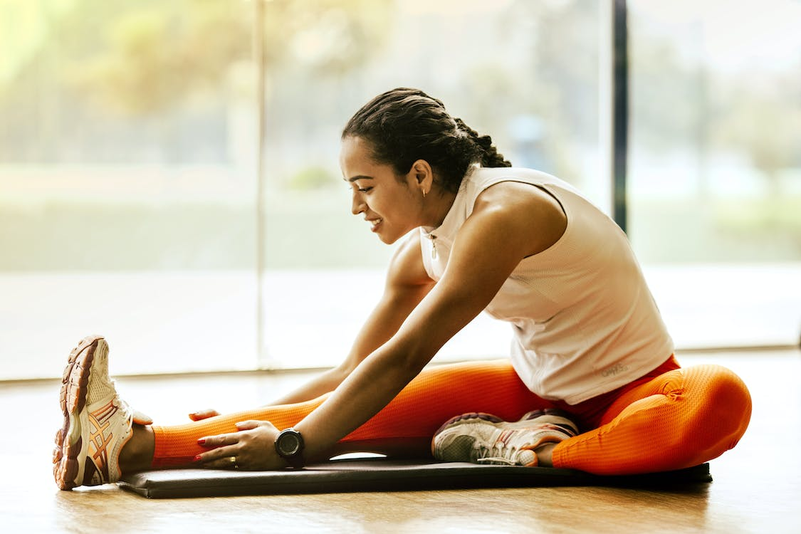 An image of a woman stretching in the gym